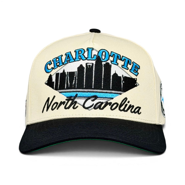 Retro-style Charlotte Snapback featuring a skyline silhouette with CHARLOTTE and North Carolina text, evoking a 1993 Panthers throwback vibe.