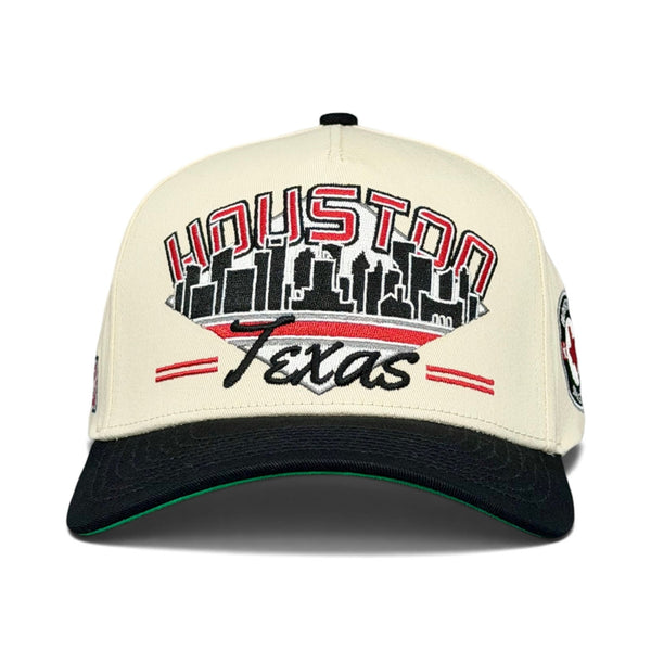 Houston Snapback - The Olajuwon: A retro baseball cap featuring a Houston skyline and Texas embroidery, evoking '94 Rockets games and honoring legendary player Hakeem Olajuwon.