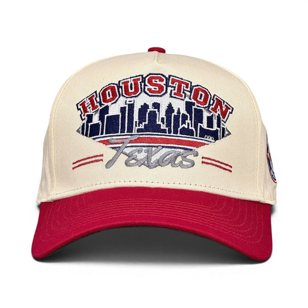 Houston Snapback - The Texan (Cream/Red) features a retro design with HOUSTON and a skyline above Texans, celebrating the Houston Texans with vintage flair.