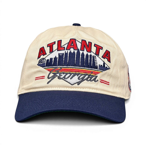 Retro Atlanta Snapback - The Aaron with off-white crown, navy brim, red ATLANTA embroidery, stylized skyline, and cursive Georgia. Perfect for Braves fans seeking vintage flair.