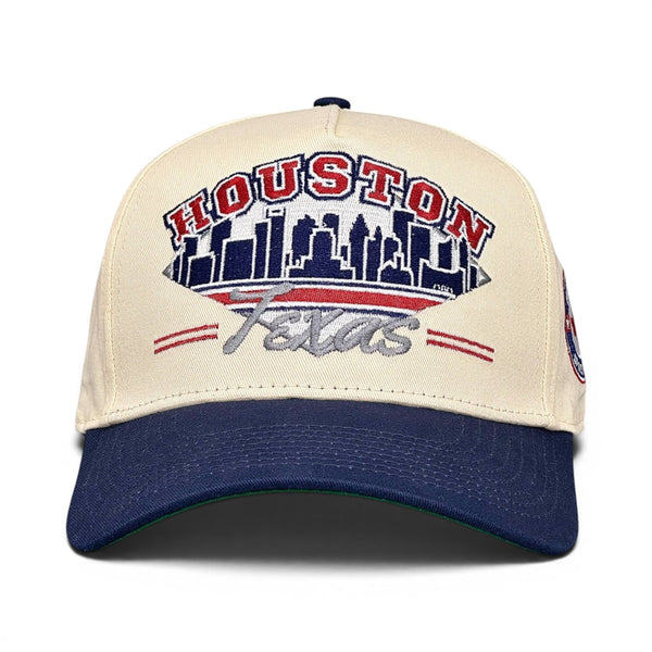 Houston Snapback - The Texan (Cream/Navy): Retro baseball cap with HOUSTON lettering, city skyline, and Astros script, evoking early 2000s Texans fan gear.