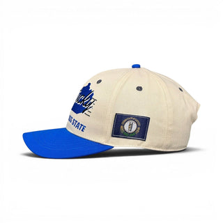 Kentucky Snapback - The Rupp (Cream/Blue) featuring Kentucky text and a Commonwealth state seal patch, inspired by Kentucky basketball and its storied arena.
