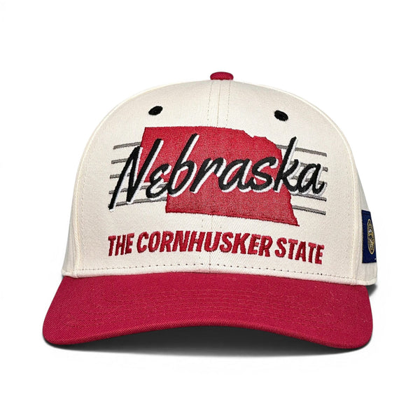 Nebraska Snapback - The Husker (Cream/Red): Retro baseball cap with Nebraska and state silhouette, celebrating Cornhuskers' tradition. Vintage-style from Shells Vintage Hat Co.