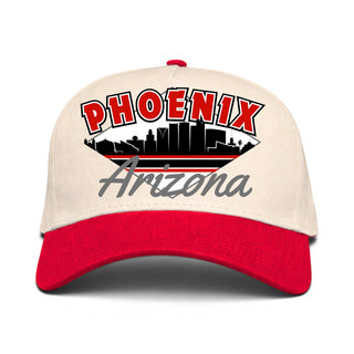 Phoenix Snapback - The Card (Cream/Red) features a retro cityscape graphic with PHOENIX and Arizona text, embodying vintage desert pride. A unique way to represent the Arizona Cardinals.