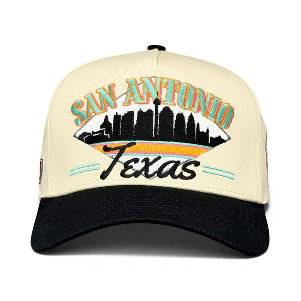San Antonio Snapback - The Popovich features a retro trucker hat design with a skyline graphic and SAN ANTONIO embroidered, capturing vintage Texan spirit.